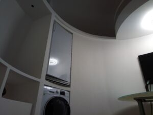 Планировка дома-шара внутри — просторная гостиная с высоким потолком.